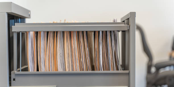 Hanging files in filling cabinet in an office at work stock photo