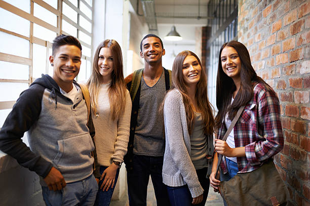 Hanging out after class Portrait of a group of students standing in a college hallway 20 24 years stock pictures, royalty-free photos & images