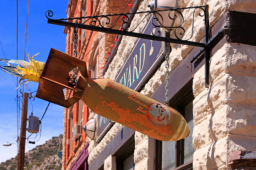 Hanging sign in the shape of a WW2 aerial bomb outside the Courtyard Restaurant on Brewery Ave in Bisbee, AZ
