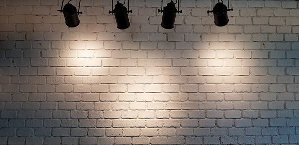 Hanging Spotlight Illuminate At White Brick Wall Background With Copy