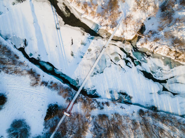 Hanging Suspention Bridge over Frozen San River in Bieszczady Mountains, Poland. Hanging Suspention Bridge over Frozen San River in Bieszczady Mountains, Poland. Drone Top Down View bieszczady mountains stock pictures, royalty-free photos & images