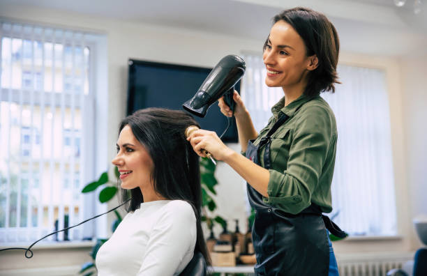 Happiness from new hairstyle. Close-up shot of a happy smiling professional stylist drying and combing hair of her satisfied client. makeup artist on working stock pictures, royalty-free photos & images