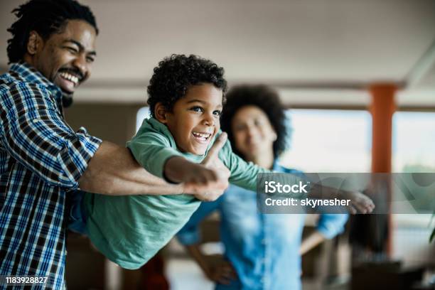 Happy African American boy having fun with his father at home.