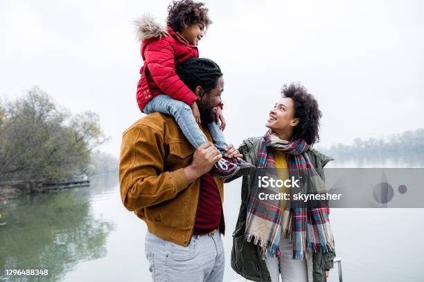 Happy African American family talking by the river.