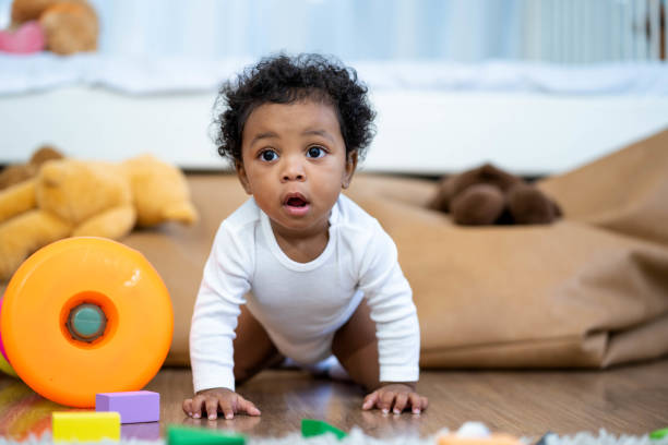Happy African American Little baby boy crawling and looking for some thing to learn Happy African American Little baby boy crawling and looking for some thing to learn baby boys stock pictures, royalty-free photos & images