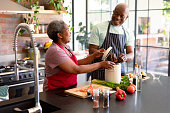 istock Happy african american senior couple cooking together in kitchen 1344525151