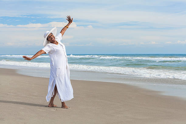 glücklich afroamerikanische frau tanzen am strand - ausgestreckte arme stock-fotos und bilder