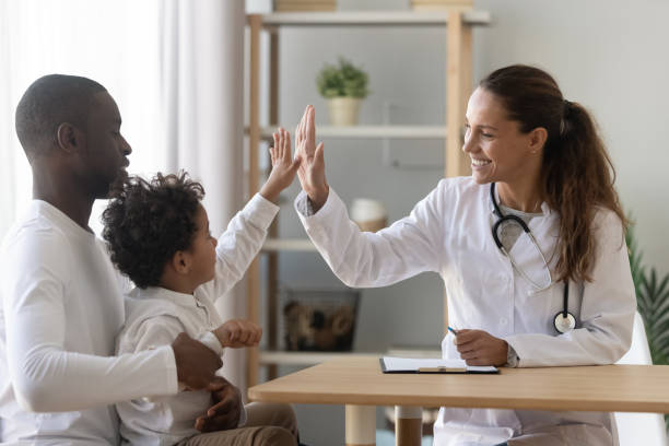 Happy african child boy give high five to female doctor Happy mixed race african cute little child boy give high five to female doctor pediatrician welcome small kid patient and his dad at medical check up appointment, children medical health care concept visit stock pictures, royalty-free photos & images