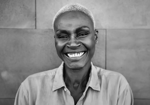 Happy Afro woman portrait - African senior female having fun smiling in front of camera - Black and white editing