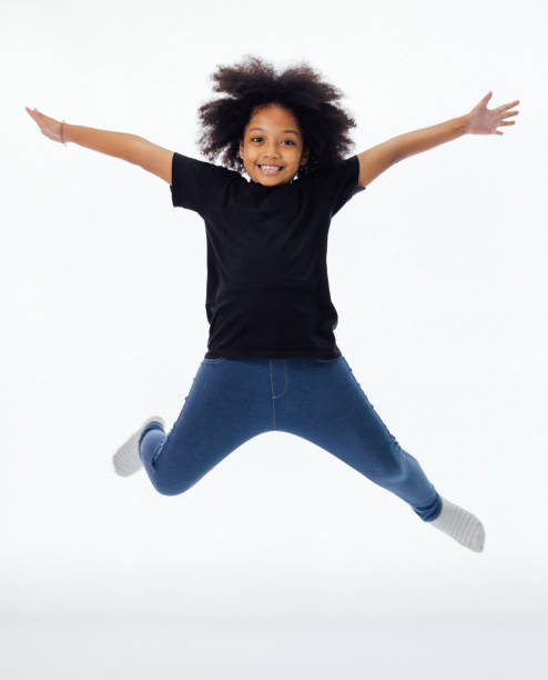 Happy and fun African American black kid jumping with hands raised isolated over white background  boy jumping stock pictures, royalty-free photos & images