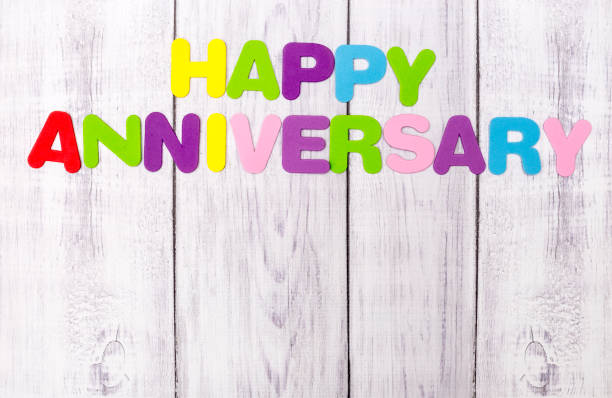 Happy Anniversary, colorful letters on wooden background
