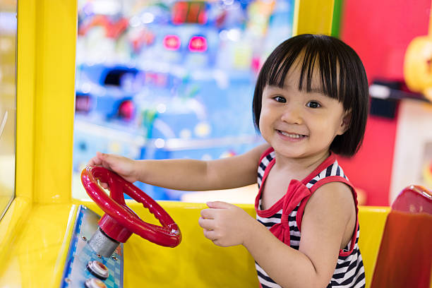 Happy Asian Chinese Little Girl Driving Toy Bus stock photo