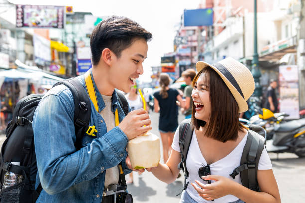 Happy Asian couple tourist backpackers traveling in Khao San road ,Bangkok stock photo