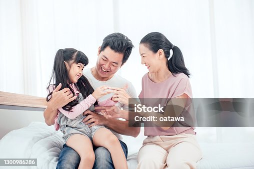 istock Happy Asian family playing together on bed while smile in bedroom at home. 1300986286