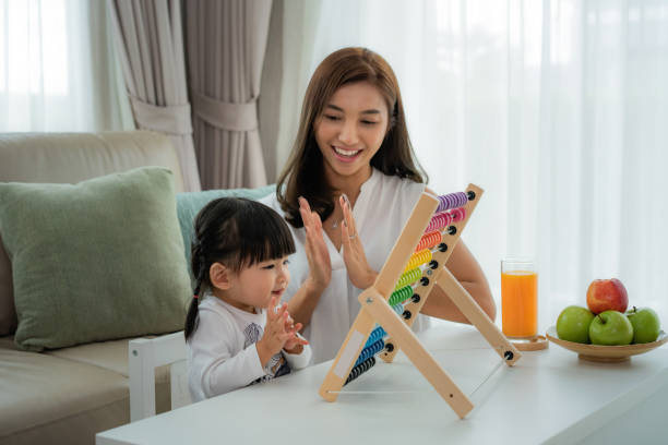 Happy Asian young mother and daughter playing with abacus, early education at home. Happy Asian young mother and daughter playing with abacus, early education at home. educate toddler stock pictures, royalty-free photos & images