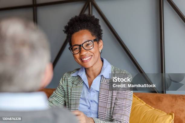 Happy black businesswoman talking to her colleague in the office.