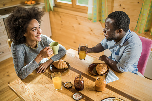 Happy Black Couple Talking To Each Other During Breakfast Time At ...