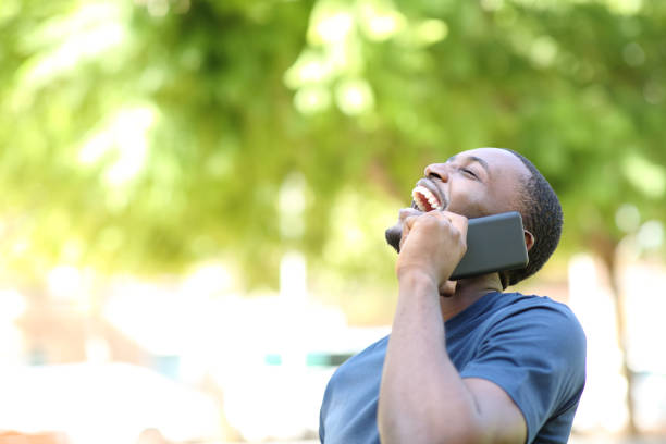 Happy black man laughing talking on phone stock photo