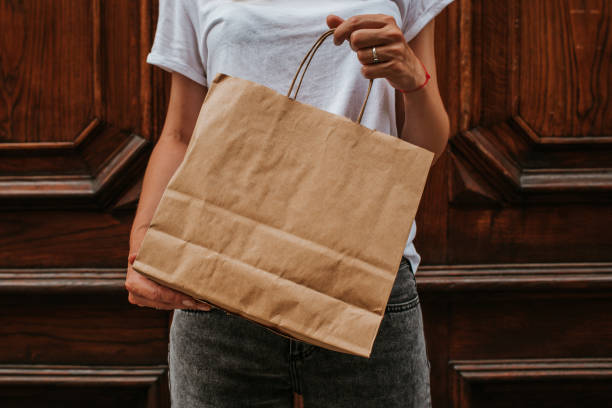 happy blond woman with shopping package in the city. paper bag. sale in store. beautiful young girl after shop. lady buy present. black friday sale. holiday special offer, discount. female love market - paper bag craft imagens e fotografias de stock