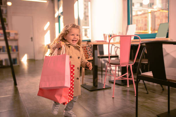 happy blonde girl running with shopping bags - foster home bag imagens e fotografias de stock