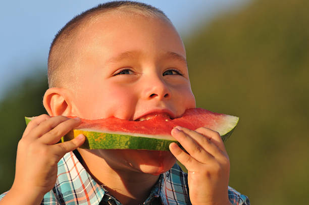 Happy boy eating sweet Watermelon stock photo