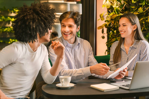 Happy business team discussing profitable annual report in cafe stock photo