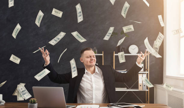 Happy businessman and flying dollar banknotes Happy businessman and flying dollar banknotes in office. Satisfied man celebrating successful investment project and great profit money rain stock pictures, royalty-free photos & images