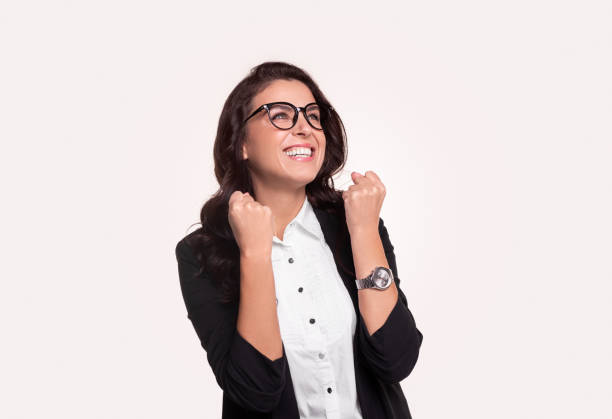 Happy businesswoman clenching fists and celebrating success stock photo