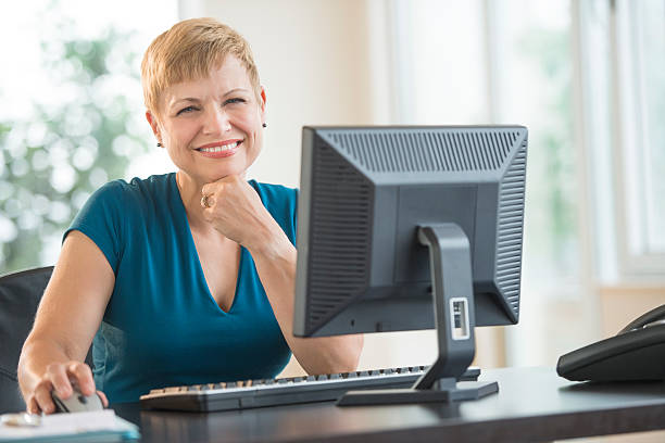 Happy Businesswoman Sitting At Computer Desk stock photo
