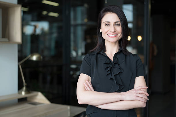 Happy businesswoman standing arms crossed Portrait of happy businesswoman standing arms crossed in office. Confident female professional is at workplace. Beautiful executive is in formals. 30 39 years stock pictures, royalty-free photos & images