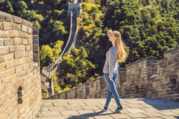 Happy cheerful joyful tourist woman at Great Wall of China having fun on travel smiling laughing and dancing during vacation trip in Asia. Girl visiting and sightseeing Chinese destination Happy cheerful joyful tourist woman at Great Wall of China having fun on travel smiling laughing and dancing during vacation trip in Asia. Girl visiting and sightseeing Chinese destination. badaling great wall stock pictures, royalty-free photos & images