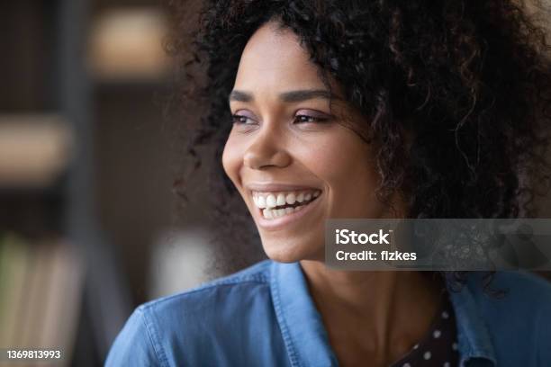 Happy cheerful pretty Black girl looking away with toothy smile