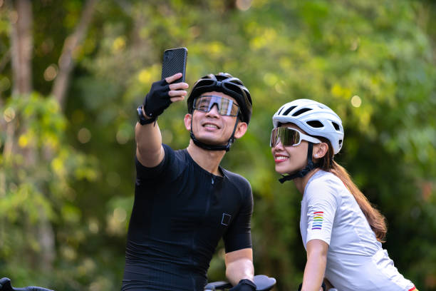 happy couple cycle selfie with smart phone during ride on rode in countryside for health life style stock photo