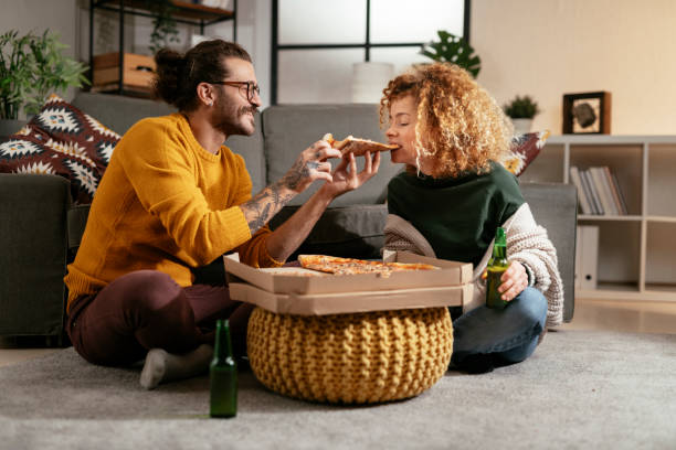 Happy couple eating pizza at home. stock photo stock photo