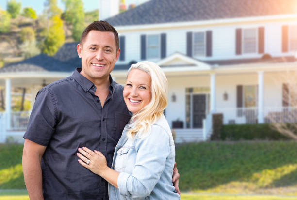 Happy Couple In Front of Beautiful House Happy Couple In Front of Beautiful House. in front of stock pictures, royalty-free photos & images