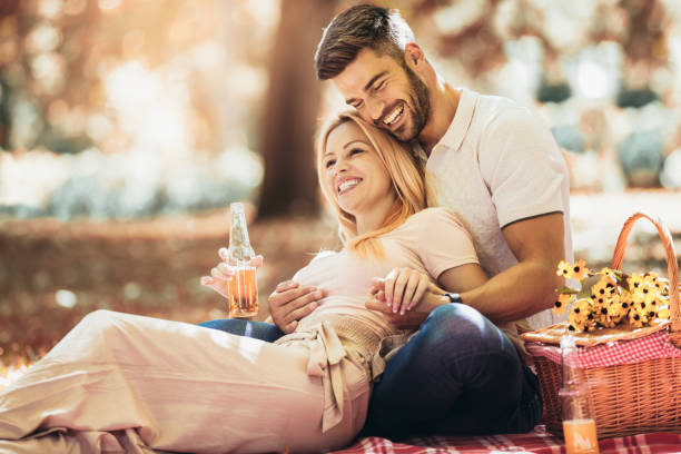 Happy couple picnic in the park during autumn fall season stock photo