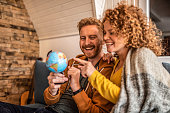 Young ginger couple looking at globe together. Looking for their new travel destination.