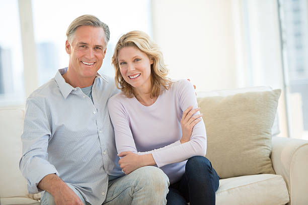Happy Couple Sitting On Sofa In Living Room stock photo
