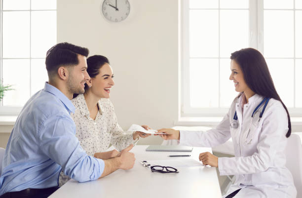 Happy couple take medical prescription that their general practitioner gives them stock photo