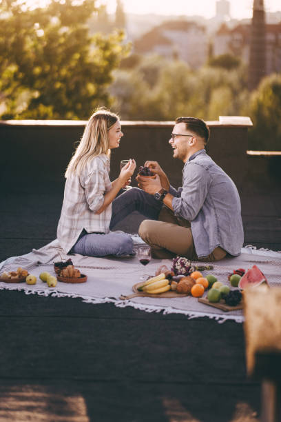 Happy couple talking while having picnic on a patio. stock photo