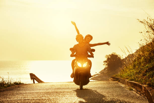Happy couple travel motorcycle sea road Happy couple traveling on motorcycle on sea coastal road. Travel concept motor scooter stock pictures, royalty-free photos & images