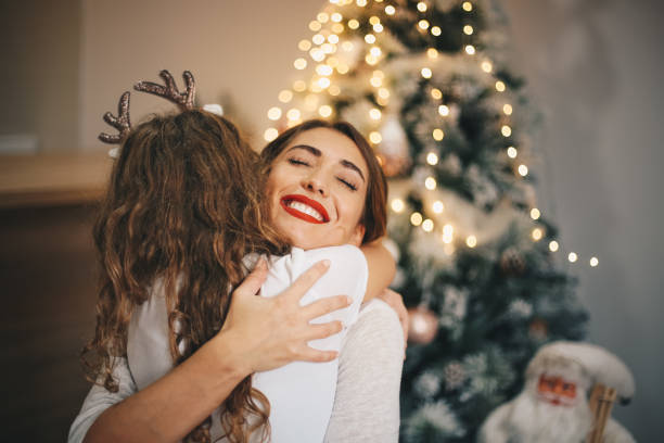 Happy daughter embracing her mother on New Year's day. Happy daughter embracing her mother on New Year's day. new years day stock pictures, royalty-free photos & images