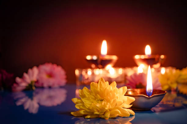 Happy Diwali. Traditional symbols of Indian festival of light. Burning diya oil lamps and flowers on red background. stock photo