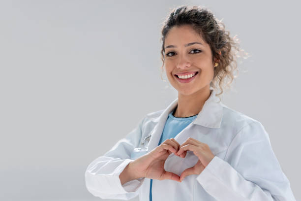 Portrait of a happy Latin American doctor making a heart shape and smiling â cardiology concepts
