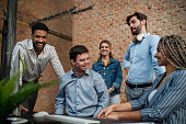 istock Happy down syndrome man with business colleagues in office, social inclusion and cooperation concept. 1340875480