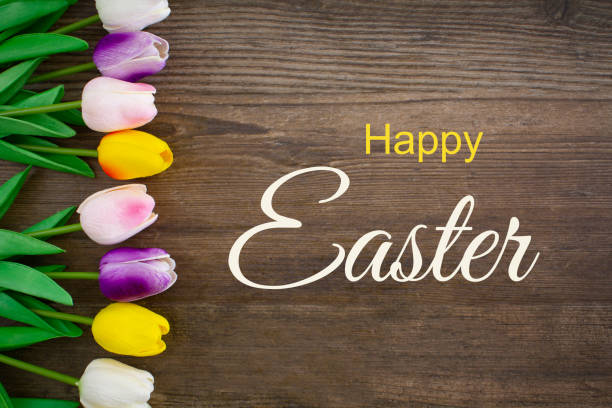 Happy Easter Happy Easter written on a rustic wooden background with tulips. easter sunday stock pictures, royalty-free photos & images