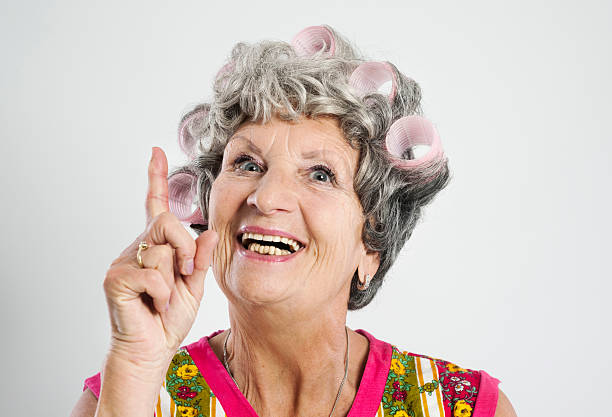 Happy elderly housewife "Stereotypical houswife with curlers, 69 years old, isolated on whiteOther photos of this model:" ugly old women stock pictures, royalty-free photos & images