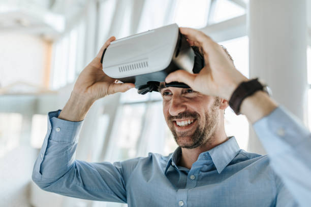 glückliche unternehmer mit spaß bei der verwendung von virtual-reality-simulator. - vr brille stock-fotos und bilder