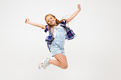 happy european girl jumping on a white wall.