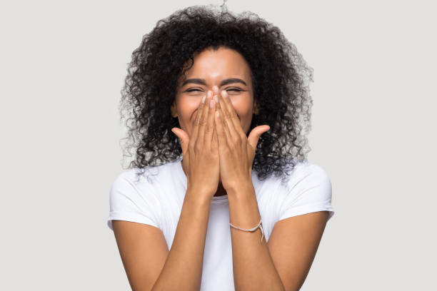 Happy excited african woman isolated on grey blank background Black woman in white t-shirt over grey blank cant believe in luck cover face with hands feels excitement happiness, winner victory moment dream come true or big problems negative emotions crying girl teardrop stock pictures, royalty-free photos & images